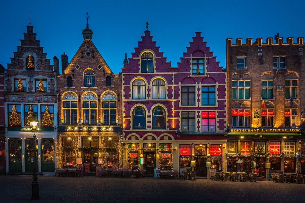 Bruges shops and cafes in the main square at night, Belgium